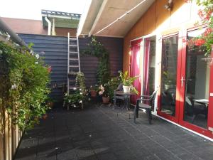 un patio con tavolo, sedie e piante di B&B 16C Maassluis NL a Maassluis