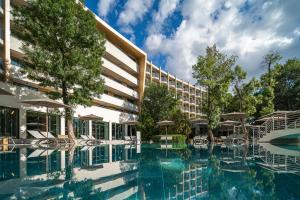 a hotel swimming pool with chairs and umbrellas at HVD Club Bor Ultra All Inclusive - Private Beach & Free parking in Sunny Beach