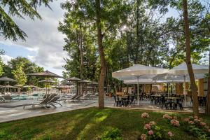 a patio with tables and chairs and umbrellas at HVD Club Bor Ultra All Inclusive - Private Beach & Free parking in Sunny Beach