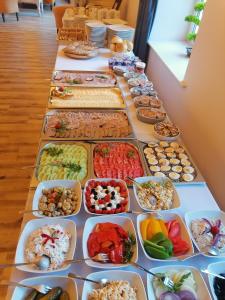 een lange tafel gevuld met verschillende soorten voedsel bij Sepia Restauracja & Noclegi in Jasło