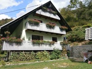 een huis met witte balkons en bloemen erop bij Apartment Žvan in Bohinj