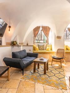 ein Wohnzimmer mit einem Sofa und einem Tisch in der Unterkunft Flora Valley Boutique Hotel in Jerusalem