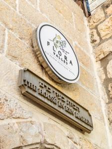 a sign on the side of a brick building at Flora Valley Boutique Hotel in Jerusalem