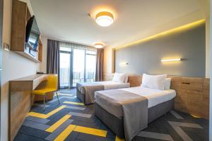 een hotelkamer met 2 bedden en een bureau bij HVD Club Bor - 24 Hours Ultra All Inclusive in Sunny Beach
