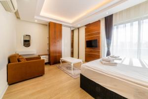 a bedroom with a bed and a chair and a television at TEMA LARA APART in Antalya
