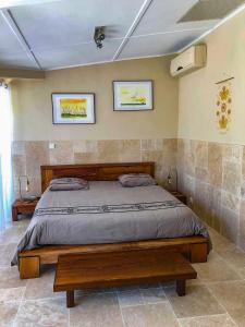 a bedroom with a large bed and two pictures on the wall at Lotus Garden - Île de la Réunion in Ravine des Cabris