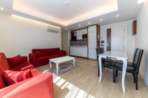 ein Wohnzimmer mit einem roten Sofa und einem Tisch in der Unterkunft TEMA LARA APART in Antalya