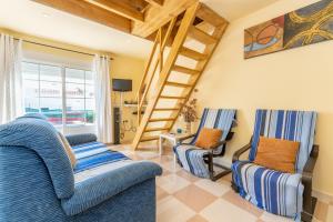 ein Wohnzimmer mit 2 Stühlen und einer Leiter in der Unterkunft Villa Flor de Lis in Cala en Porter