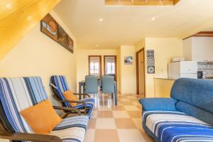 ein Wohnzimmer mit einem blauen Sofa und Stühlen in der Unterkunft Villa Flor de Lis in Cala en Porter