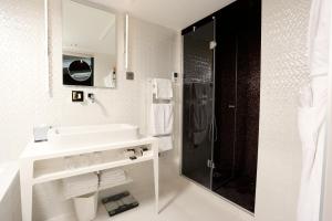 a white bathroom with a sink and a shower at Le Malown in Paris