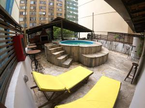 um pátio com uma piscina, cadeiras e uma mesa em Che Lagarto Hostel Copacabana no Rio de Janeiro