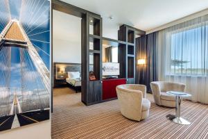 una camera d'albergo con vista su una camera da letto di ETO Park Hotel Business & Stadium a Győr