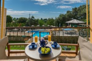 - une table avec un bol de fruits sur le balcon dans l'établissement Villa Yannis, à Kato Korakiana