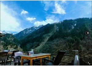 a restaurant with tables and chairs and a mountain at Olive Garden Classic in Tosh