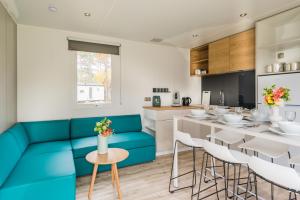 a kitchen and dining room with a blue couch at Chalet O'hara in Bilthoven