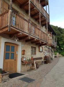 a building with a balcony and a wooden door at Agritur Masi Brenta in Rovereto