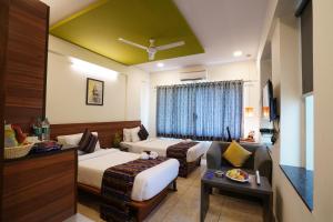 a hotel room with two beds and a couch at Silicon Inn Hotel Bangalore Airport in Devanahalli-Bangalore