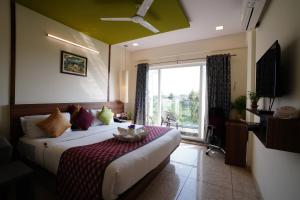 ein Schlafzimmer mit einem Bett und einem großen Fenster in der Unterkunft Silicon Inn Hotel Bangalore Airport in Devanhalli + 37 Fotos