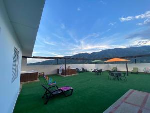 eine Terrasse mit Stühlen und Tischen auf dem Dach eines Gebäudes in der Unterkunft HOTEL VERANO in Ibagué