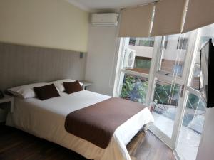 1 dormitorio con cama y ventana grande en Hotel Elisa Cole en Santiago