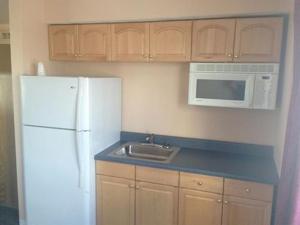 a kitchen with a white refrigerator and a sink at Collins Avenue Hostel in Miami Beach