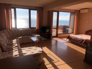 a living room with a couch and a bed at Relax Guest House in Burgas