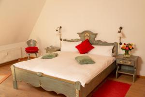 a bedroom with a large bed with red pillows at Hotel Wappenstube in Erbach