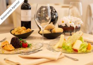 a table topped with plates of food and wine glasses at Grand Hotel Impero Spa & Resort in Castel del Piano