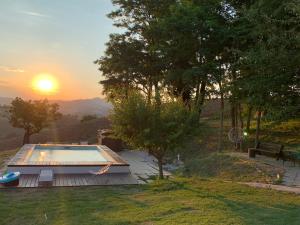 una piscina con puesta de sol en el fondo en Casale Grifondoro, en Pergola