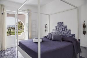 a bedroom with a large bed with a purple bedspread at Mari del Sud Resort in Vulcano
