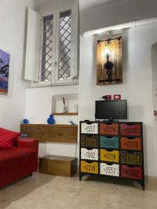 un soggiorno con divano rosso e TV di Casa Margot a Napoli