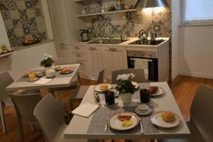 una cocina con 2 mesas y sillas con comida. en Lo Schiaccianoci B&B, en Taranto