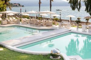 a swimming pool at a resort with tables and chairs at Grand Hotel Fasano & Villa Principe in Gardone Riviera