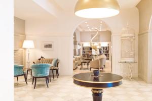 a living room with a table and chairs at Grand Hotel Fasano & Villa Principe in Gardone Riviera