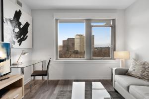 Global Luxury Suites Crystal City في أرلينغتون: غرفة معيشة مع أريكة ونافذة