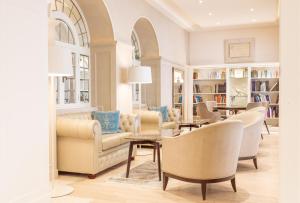 - un salon avec une table et des chaises dans l'établissement Grand Hotel Fasano & Villa Principe, à Gardone Riviera