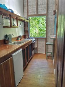 a kitchen with a sink and a window at Jungle Paunch in Bocas Town