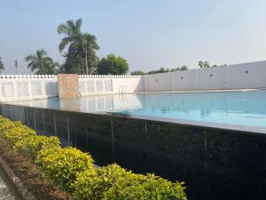 an empty swimming pool with a fence and bushes at Roop Shree Hotel in Chittaurgarh