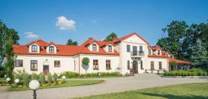 a large white house with an orange roof at Dwór Karwacz in Przasnysz