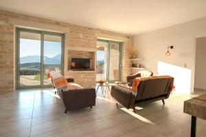 ein Wohnzimmer mit zwei Sofas und einem Kamin in der Unterkunft Villa Galliki in Kamilari