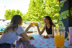 two girls sitting at a table drinking orange juice at Reina Madre Hostel in Buenos Aires