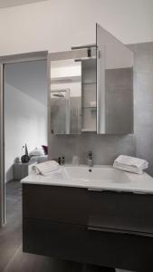 La salle de bains est pourvue d'un grand lavabo et d'un miroir. dans l'établissement Maisonette Modena Park, à Modène
