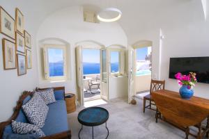 salon z niebieską kanapą i stołem w obiekcie Aloia Villas Santorini Two Bedroom Villa With Outdoor Hot Tub Spyros Demi w mieście Oia