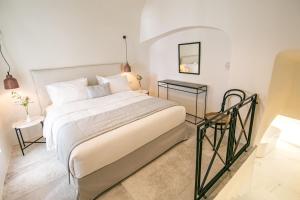 sypialnia z dużym łóżkiem i stołem w obiekcie Aloia Villas Santorini Two Bedroom Villa With Outdoor Hot Tub Spyros Demi w mieście Oia