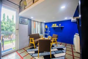 a room with a table and chairs and a blue wall at The Artist Residence in Phnom Penh