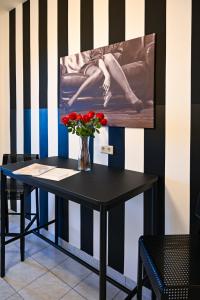 ein schwarzer Tisch mit einer Vase Blumen drauf in der Unterkunft Highlight Apartment St Charles Church in Wien