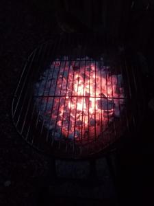 a fire in a grill in a dark room at Wee Hoose Glamping Pod 1 in Skail