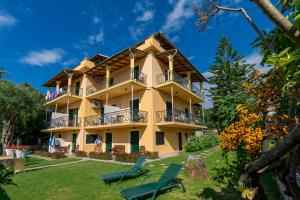 a large yellow building with chairs in the yard at Villa Yannis in Kato Korakiana