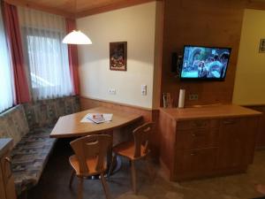 uma sala de jantar com uma mesa e uma televisão na parede em Appartement Zottl em Mayrhofen