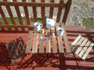 a wooden bench with cups and mugs on it at Wee Hoose Glamping Pod 1 in Skail
